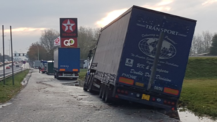 Foto Vastgereden en gekantelde vrachtwagen